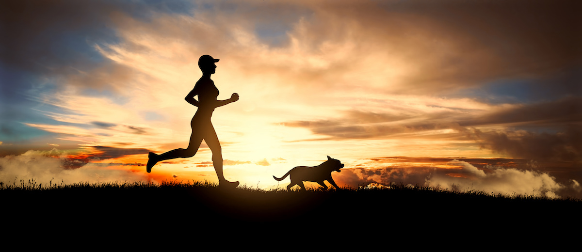 woman running with her dog in sunset
